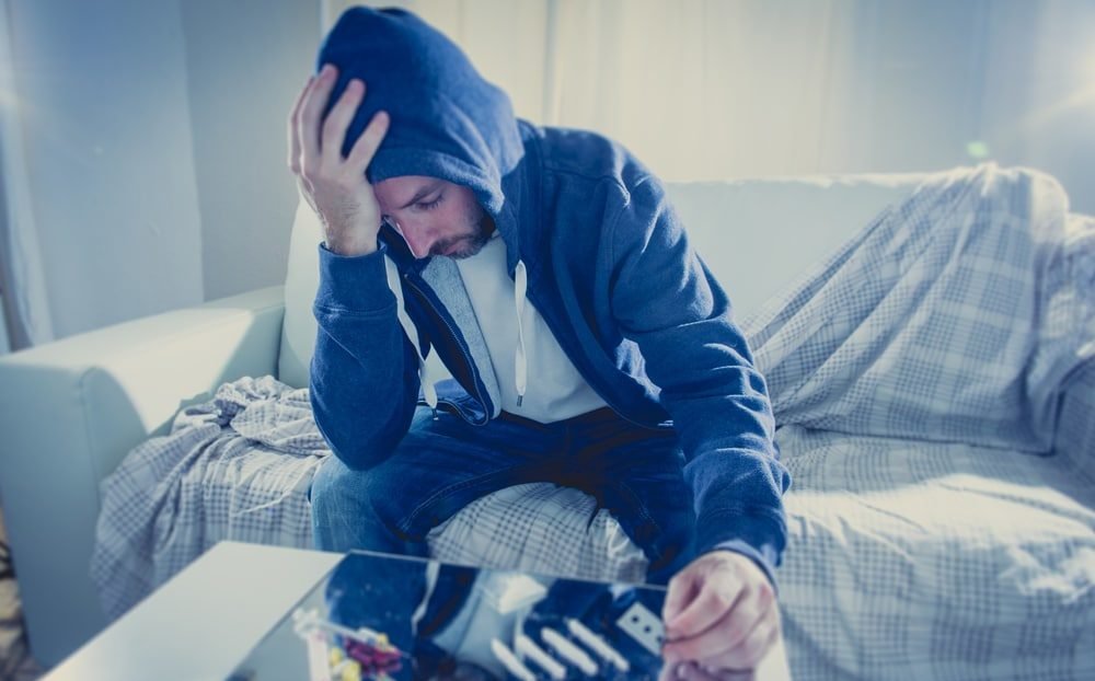 Sad man addicted to Cocaine on the couch