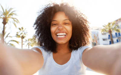 black woman smiling in a selfie, positive mental health, warm weather