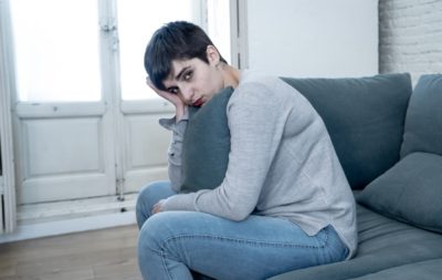 Depressed woman on sofa feeling sad