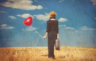 young woman with suitcase and balloon